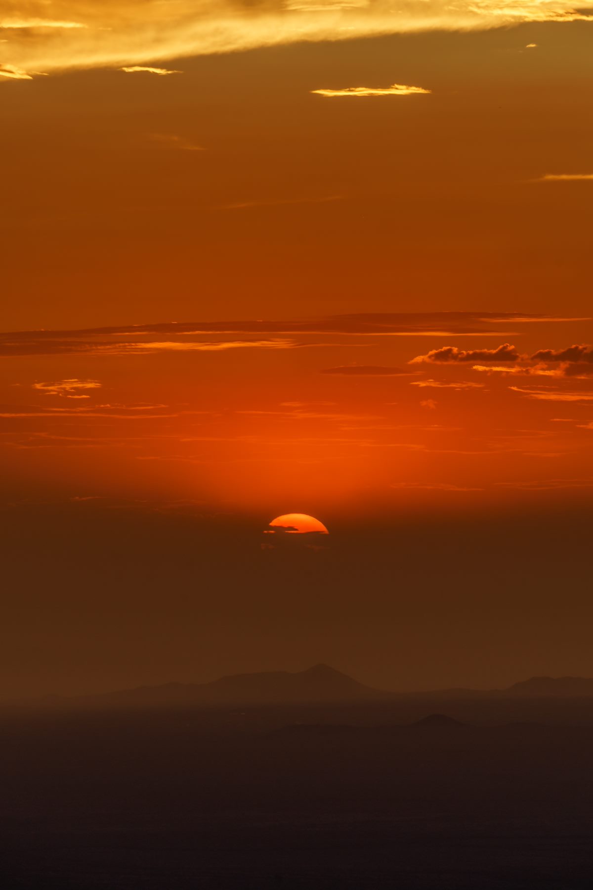 2017 July Sun disappearing behind a cloud near Sunet on Apache Peak